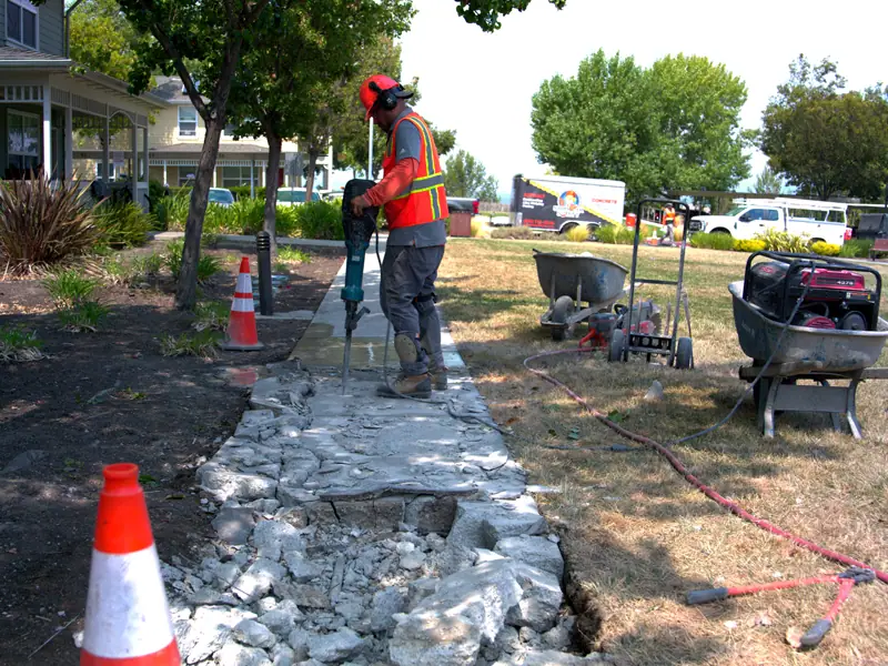 Crew breaking out a damaged sidewalk with a jackhammer